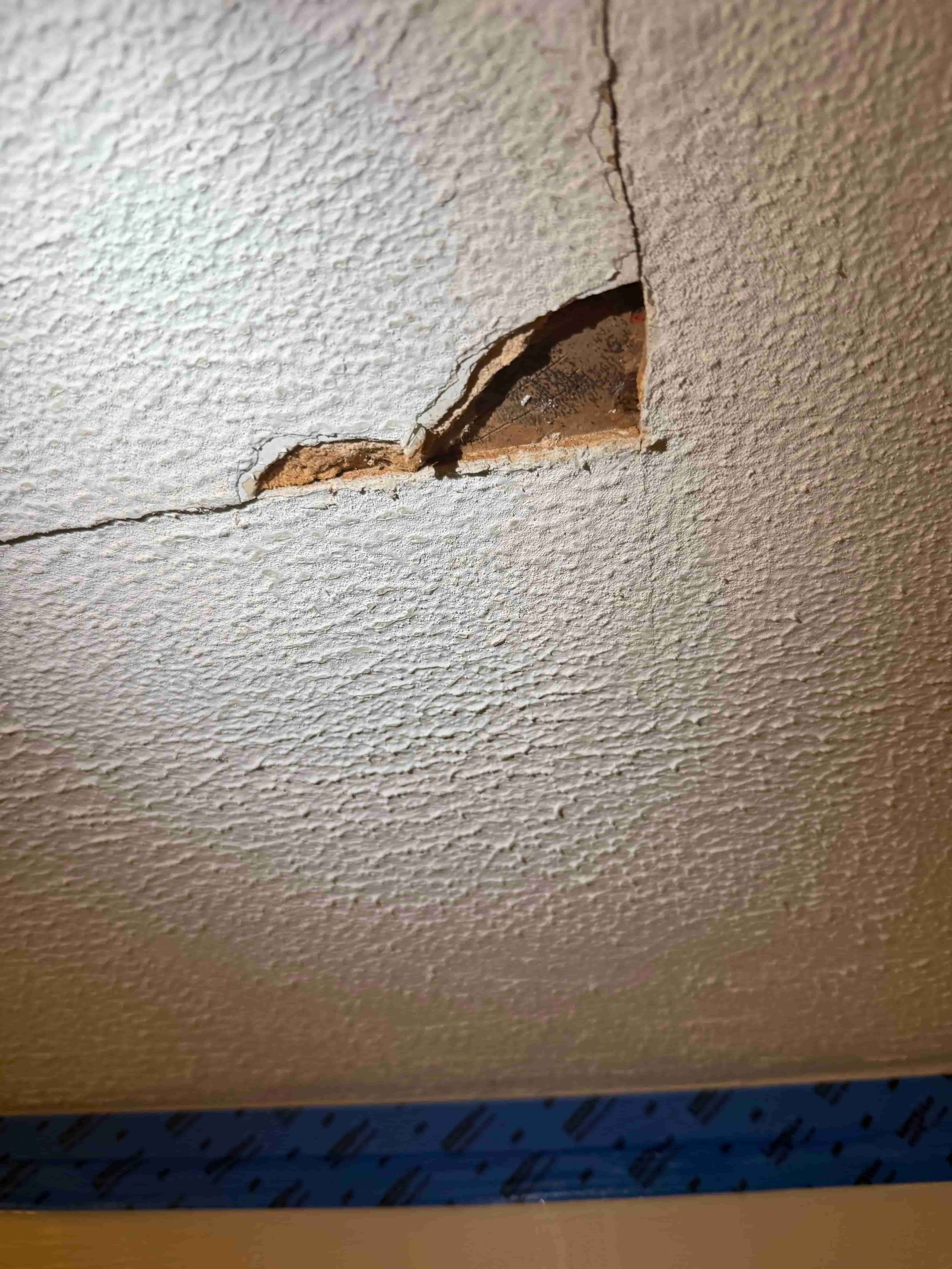 Hole in a living room ceiling in a Raleigh home, ready to be patched
