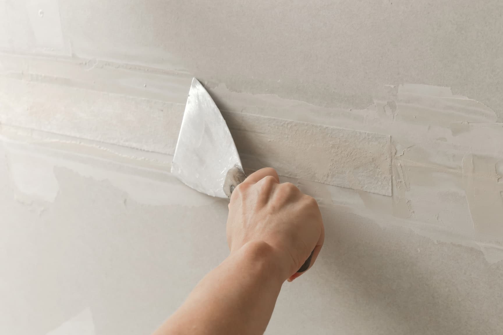 Taping and mudding drywall seams with joint compound in a Raleigh home