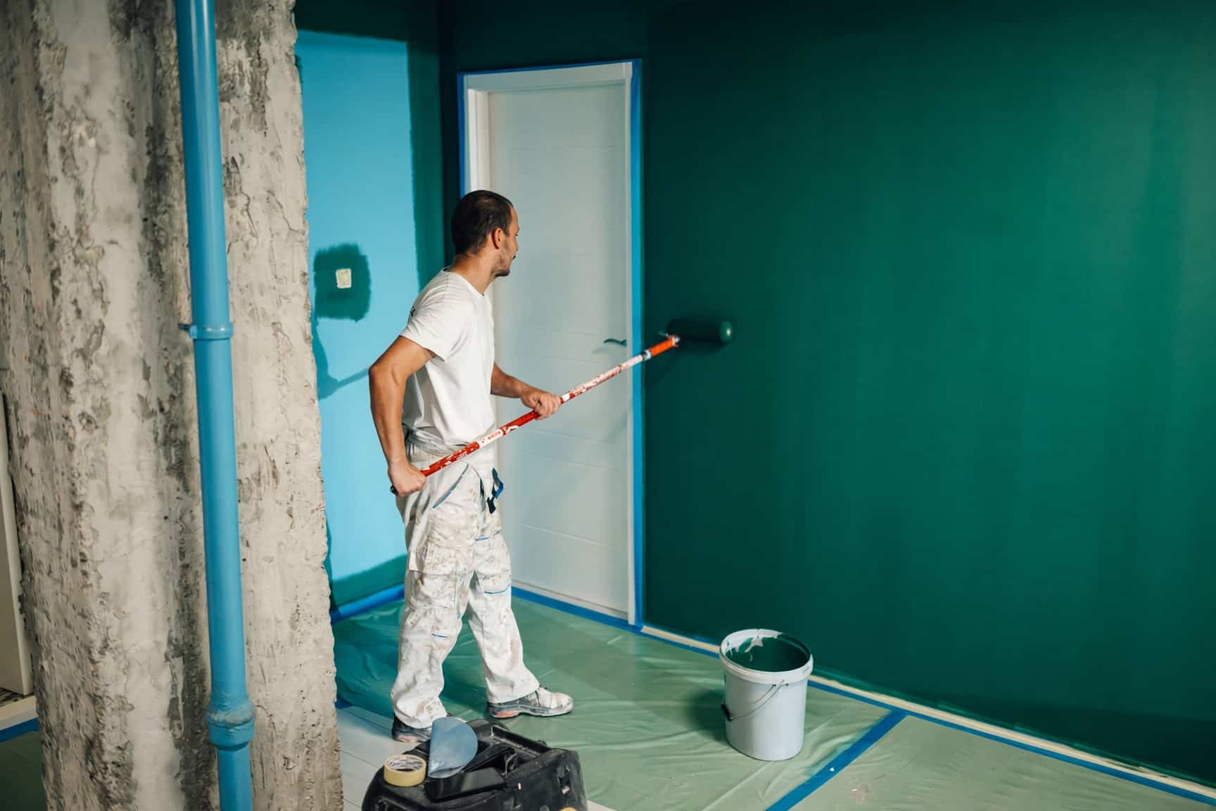 House painter rolling fresh paint on a living room wall in a Raleigh home